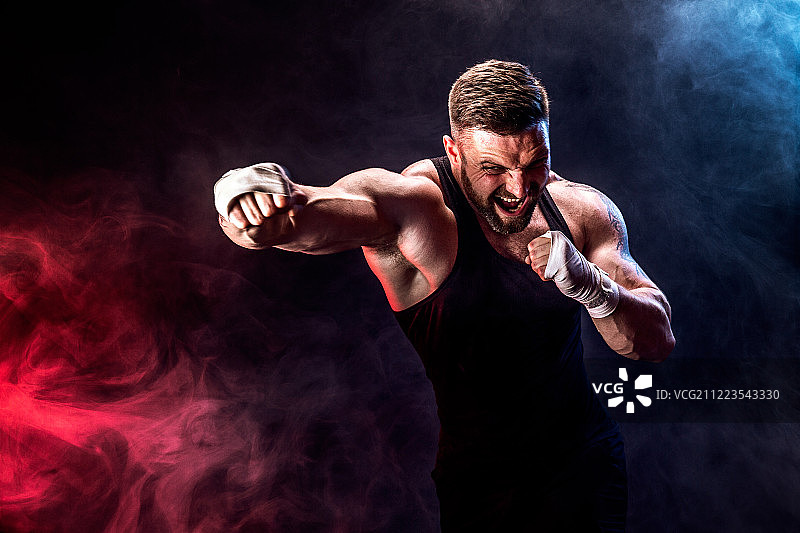 在黑色烟雾背景下战斗的泰拳拳击手图片素材
