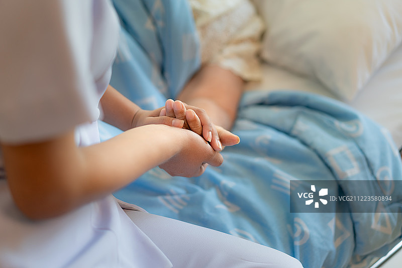 护士在病床旁帮助老年妇女图片素材