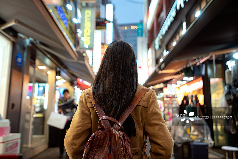 在明洞旅行和购物的年轻亚洲女性旅行者图片素材