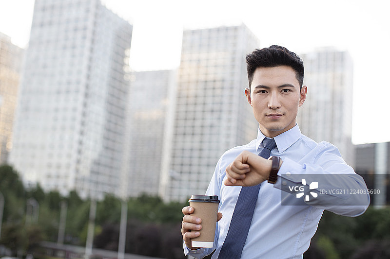 自信的年轻商务男士看时间图片素材
