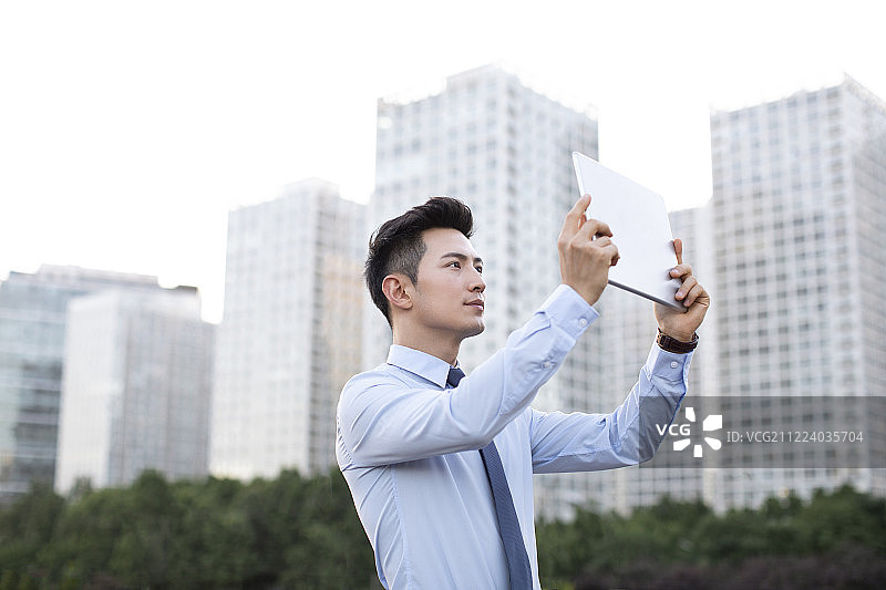 年轻商务男士使用平板电脑图片素材