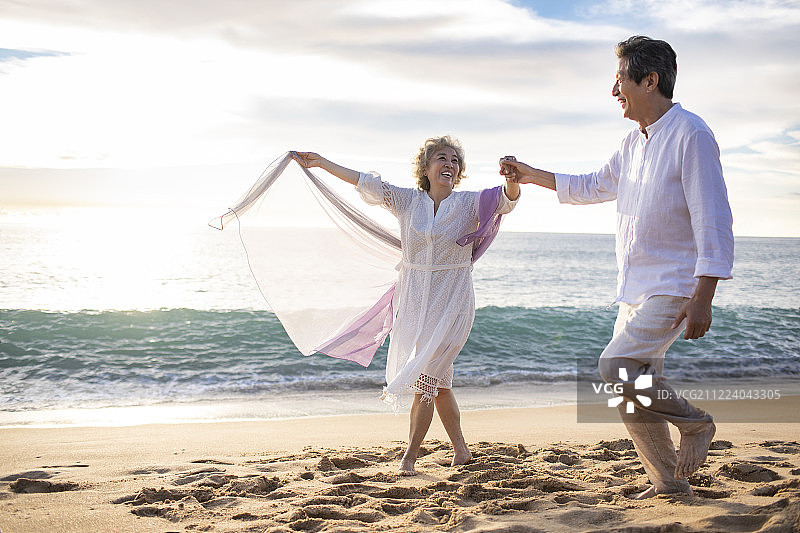 快乐的老年夫妇在沙滩跳舞图片素材