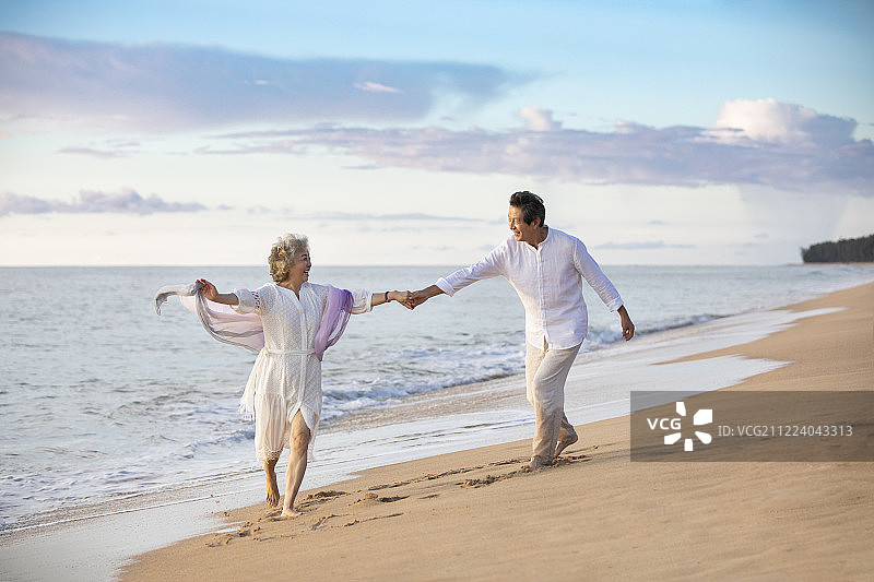 快乐的老年夫妇在沙滩跳舞图片素材