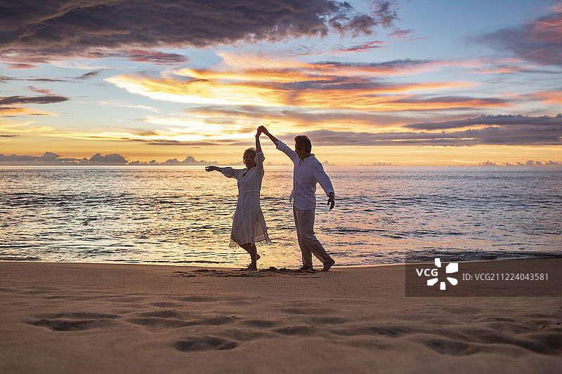 快乐的老年夫妇在沙滩跳舞图片素材