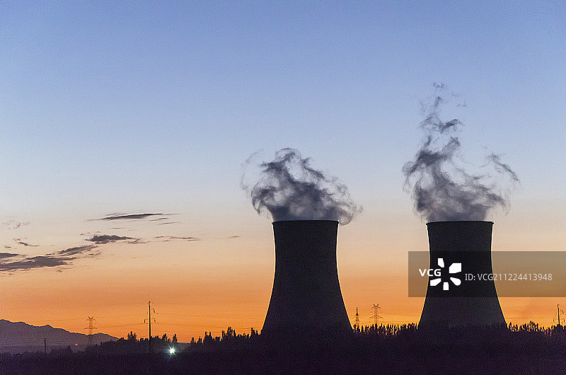 太阳下山后火电站冒烟烟囱特写剪影图片素材