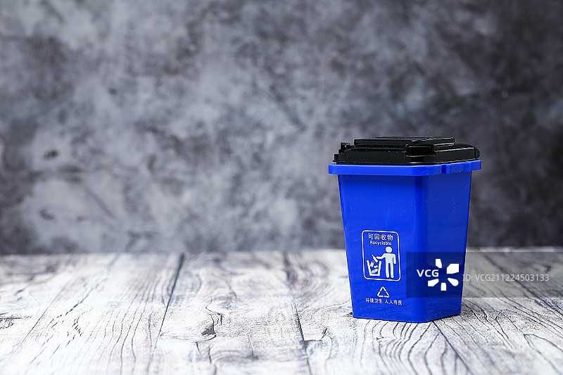 垃圾分类概念 彩色垃圾桶放在灰色木板背景前图片素材