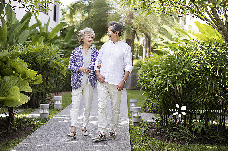 快乐的老年夫妇在庭院散步图片素材
