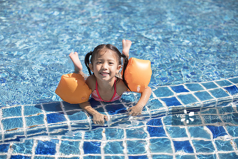 快乐的小女孩在泳池游泳图片素材