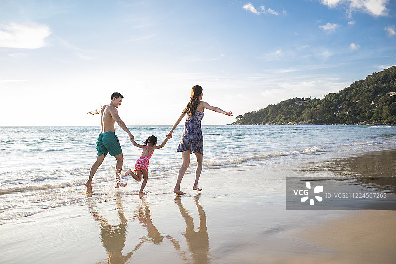 快乐的年轻家庭在沙滩玩耍图片素材