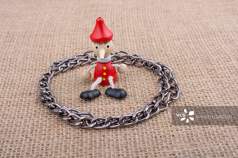 坐在帆布上的木制匹诺曹玩偶图片素材