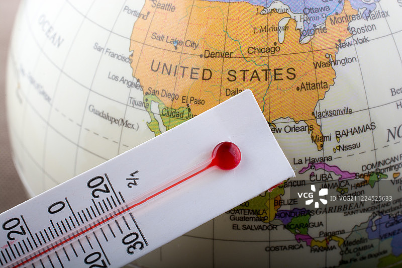 放在小模型地球仪上的温度计图片素材