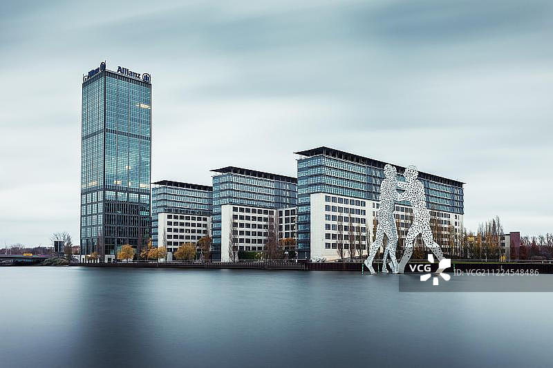 施普雷河畔的特雷普托塔和安联大厦，艺术家乔纳森·博罗夫斯基的分子人雕塑，位于德国柏林特雷普托图片素材