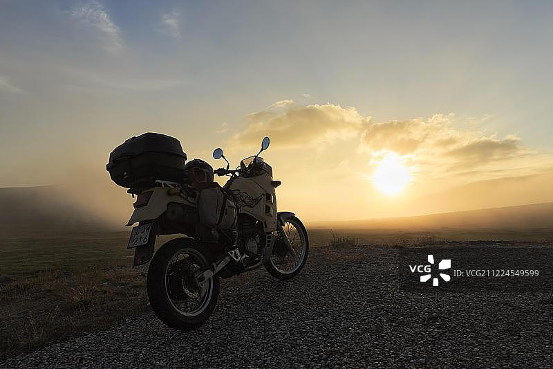 停在街道上的摩托车，午夜阳光，挪威芬马克郡马盖罗亚岛北角图片素材