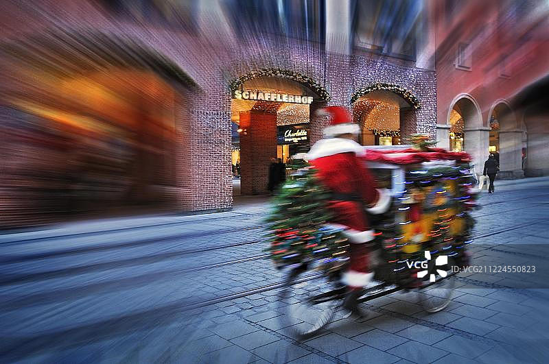 圣诞老人骑自行车送礼物，德国慕尼黑巴伐利亚图片素材