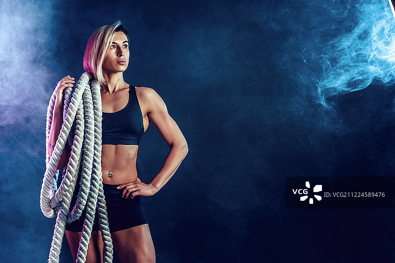 身穿黑色运动服，肩扛粗绳的迷人女人图片素材
