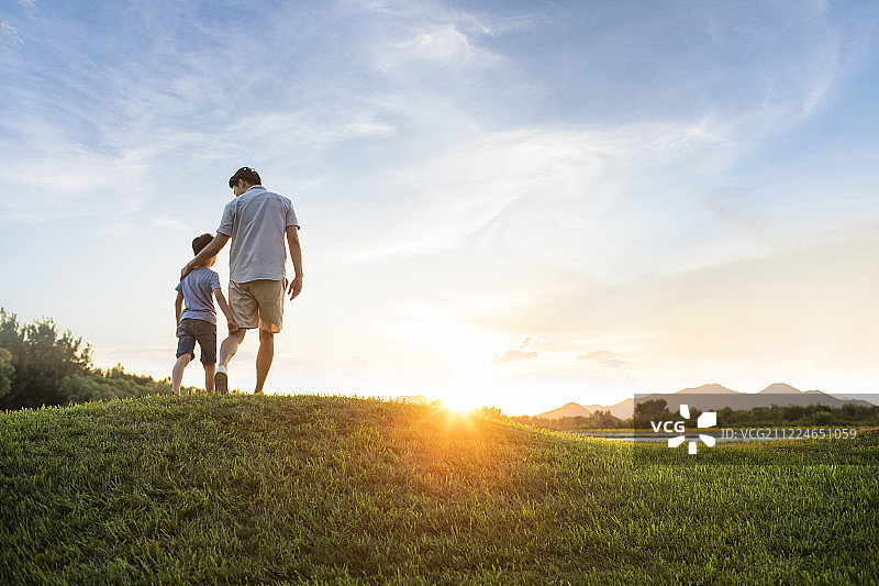 父子俩在草地上图片素材