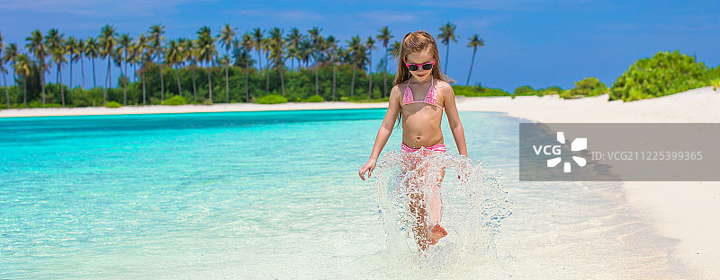 在夏季假期在海滩上的可爱小女孩图片素材