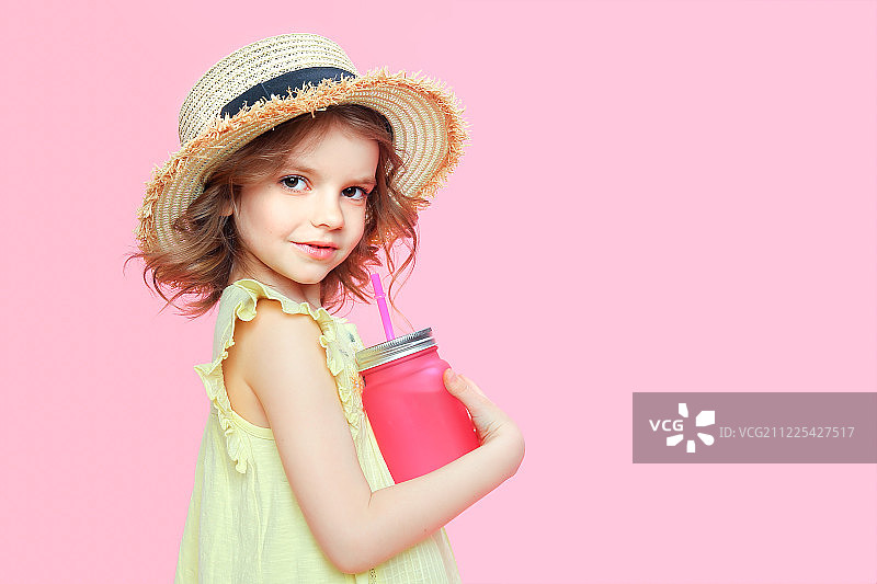 拿着饮料的时尚小女孩，粉色背景图片素材