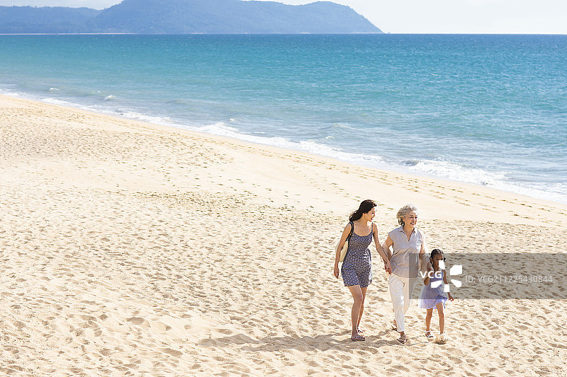 快乐的家庭在沙滩漫步图片素材
