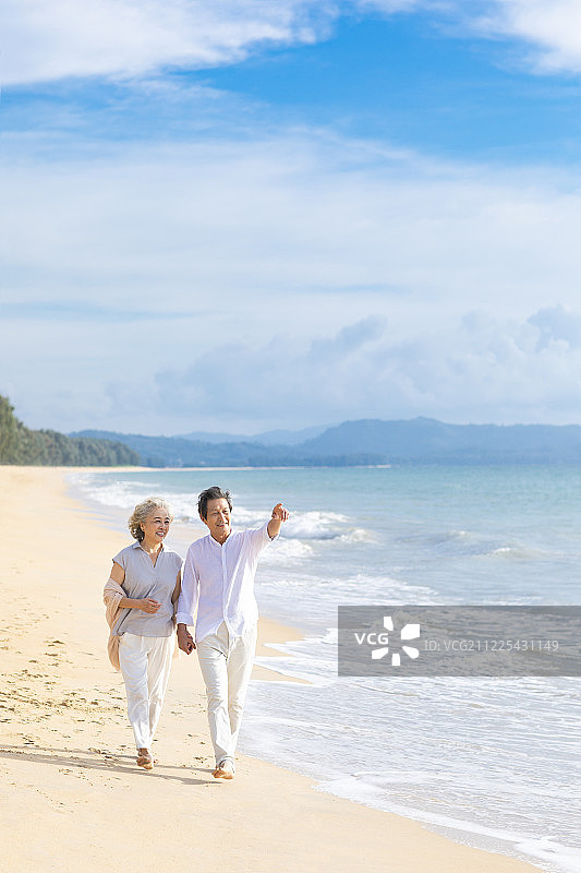 快乐的老年夫妇在沙滩散步图片素材