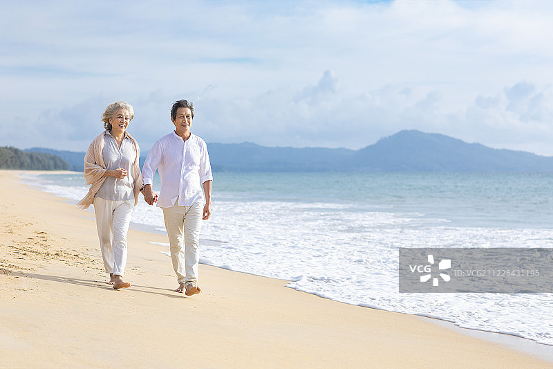 快乐的老年夫妇在沙滩散步图片素材