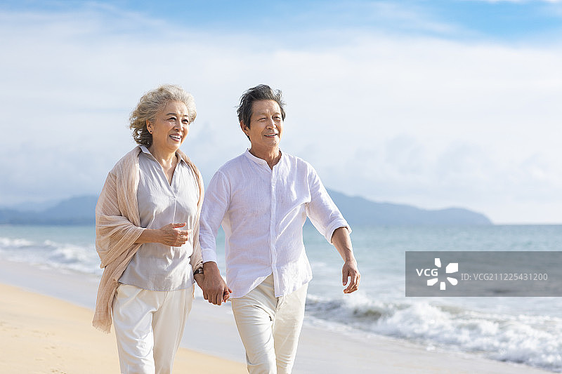 快乐的老年夫妇在沙滩散步图片素材