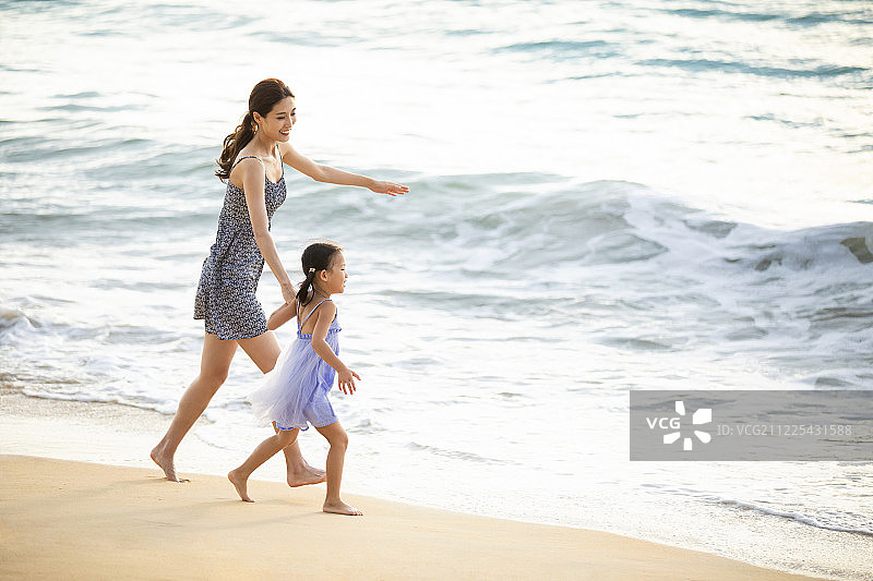 快乐的母女在沙滩上嬉戏图片素材