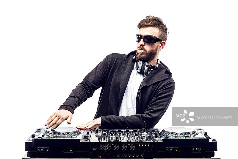 时尚男DJ在调音台前摆姿势图片素材
