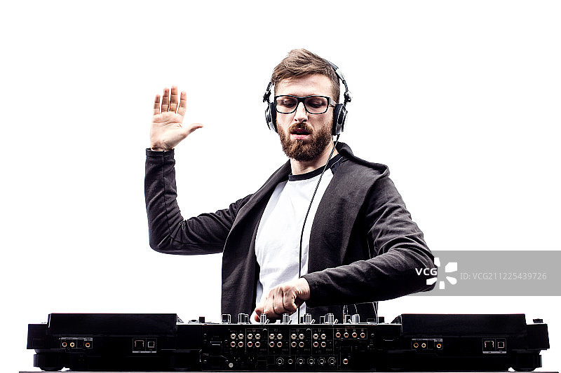 时尚男DJ在调音台前摆姿势图片素材