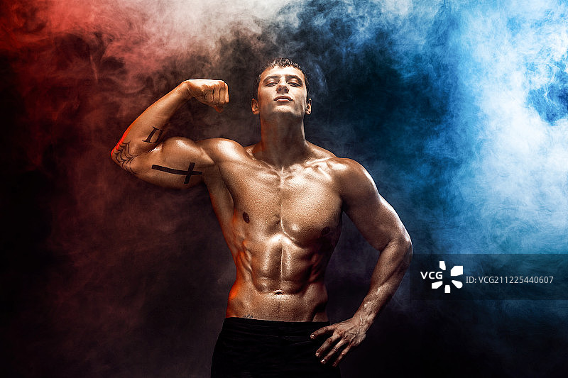 拥有完美腹肌、肩膀、肱二头肌、肱三头肌和胸肌的健壮男子图片素材