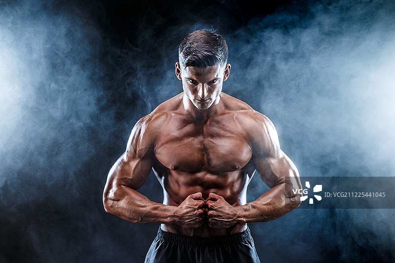 拥有完美腹肌、肩膀、二头肌、三头肌和胸肌的健美男子图片素材