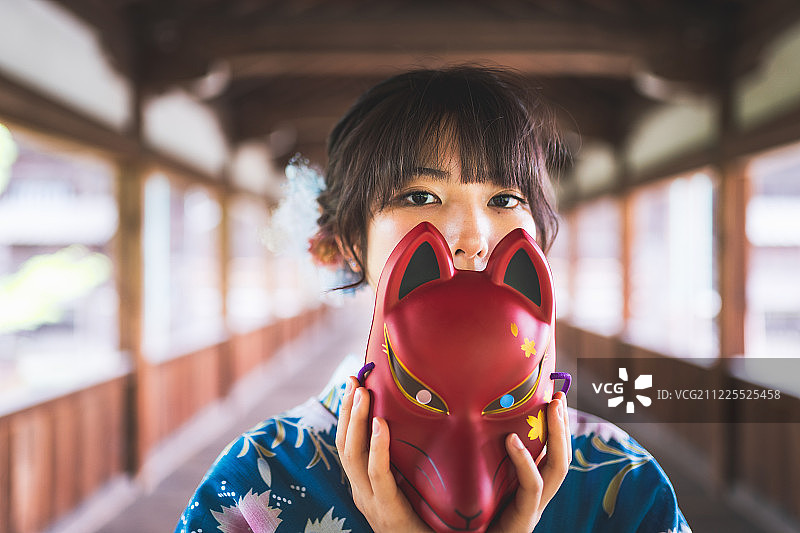 身穿和服手持面具遮面的日本女人图片素材