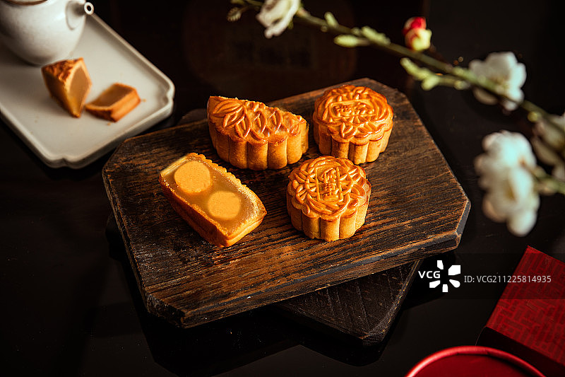 一块切开的双黄白莲蓉月饼放在桌子上图片素材
