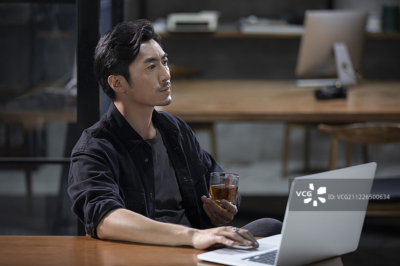 摄影师在工作室使用笔记本电脑图片素材