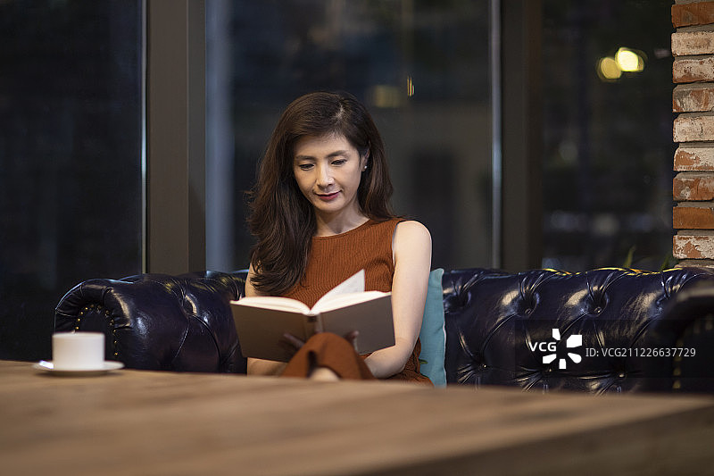 中年女性在咖啡馆看书图片素材