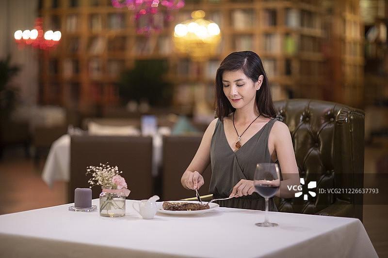 优雅女士在餐厅吃牛排图片素材