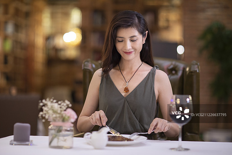 优雅女士在餐厅吃牛排图片素材