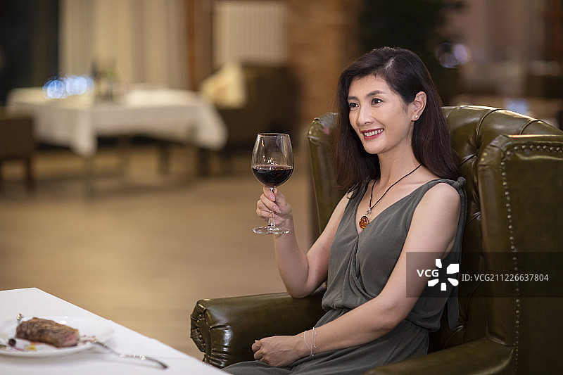优雅女士在餐厅品尝红酒图片素材