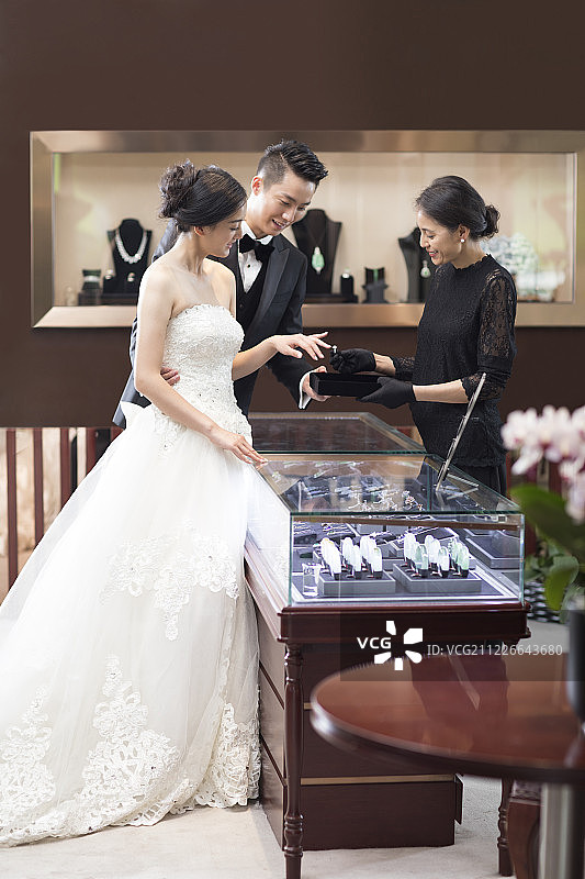 幸福的新娘和新郎在珠宝店挑选戒指图片素材