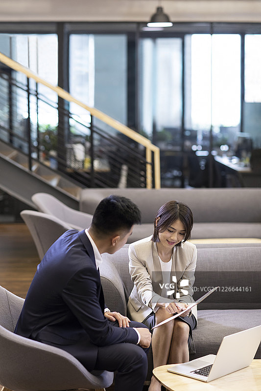 年轻商务男女在办公室讨论图片素材
