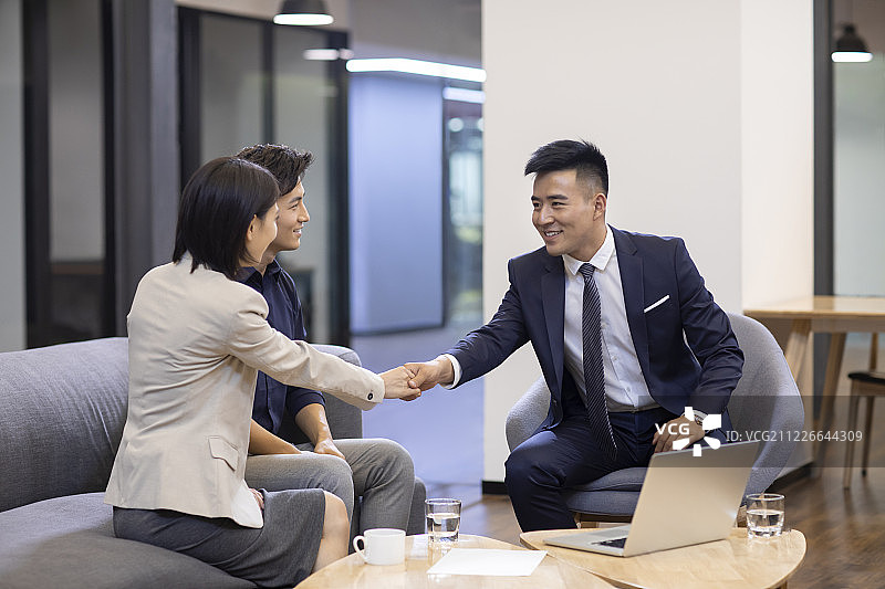 自信的商务人士在办公室握手图片素材