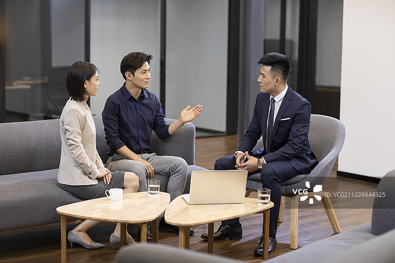 自信的商务人士在办公室讨论图片素材