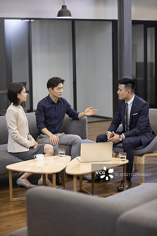 自信的商务人士在办公室讨论图片素材