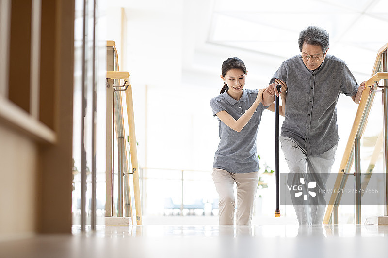 年轻女护士扶老人上楼图片素材