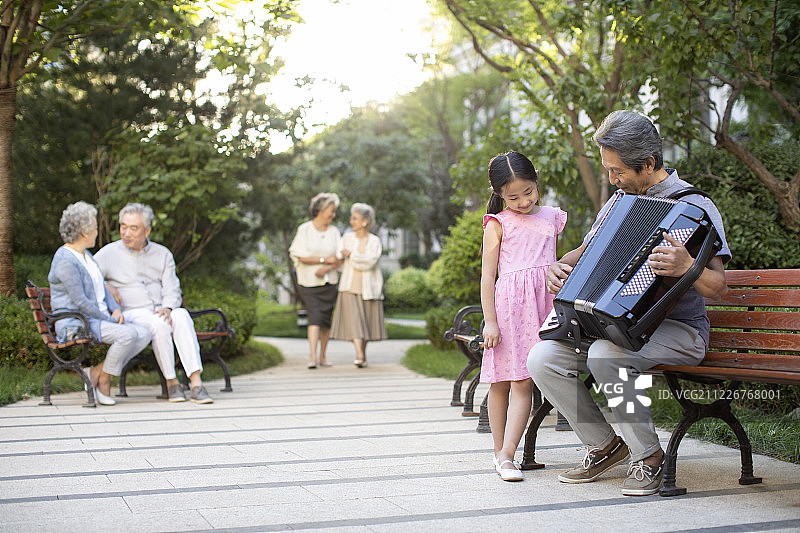 祖孙俩在公园弹手风琴图片素材