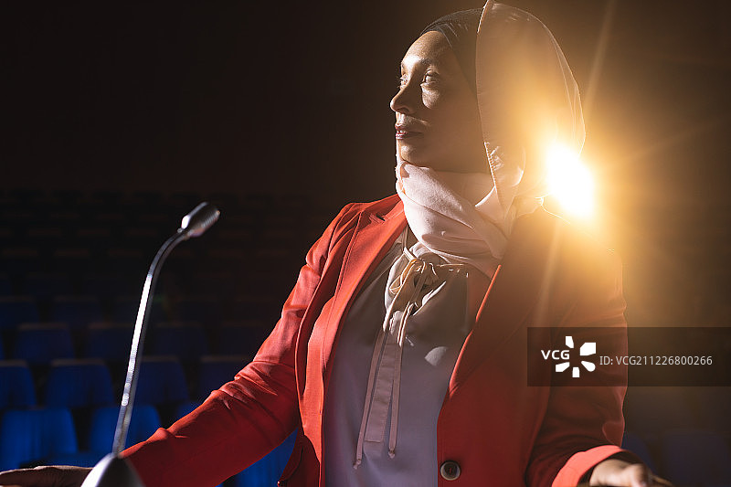 女商人站在礼堂的舞台上思考图片素材