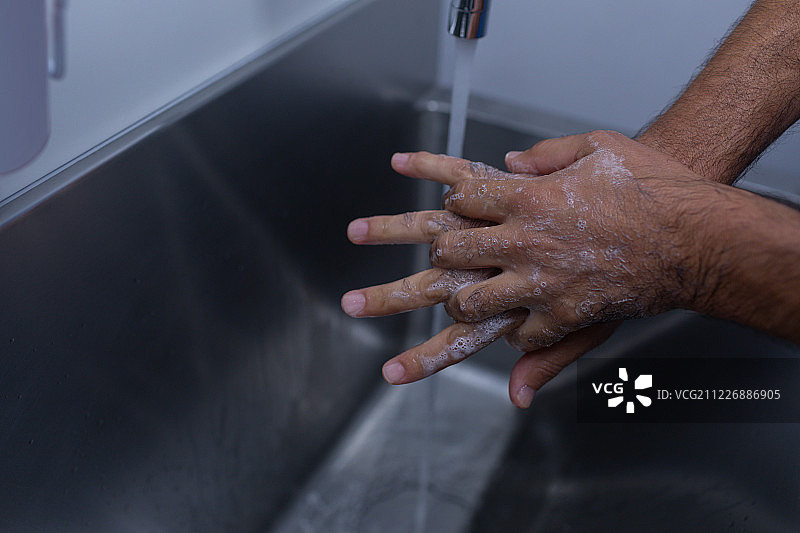男外科医生在医院的水槽里洗手图片素材