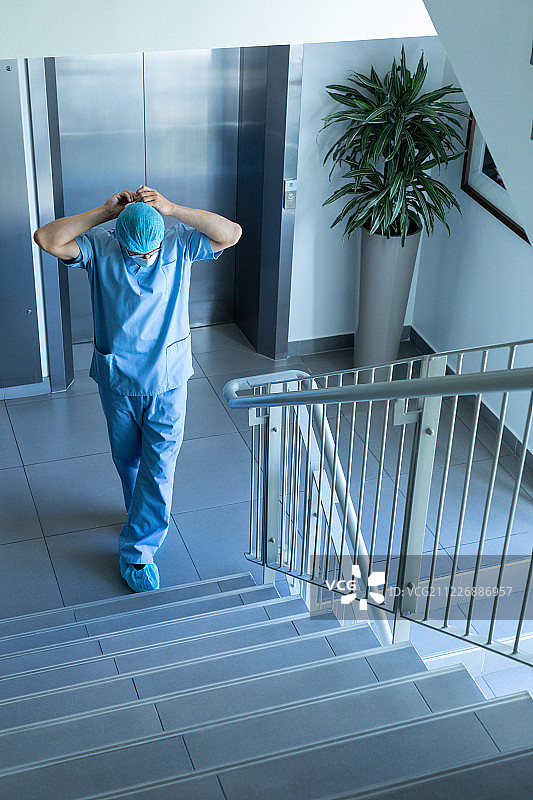 站在楼梯上戴着外科口罩的外科男医生图片素材