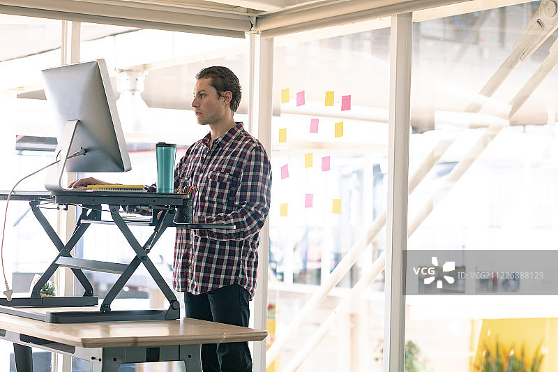 在办公桌上用电脑工作的男性平面设计师图片素材