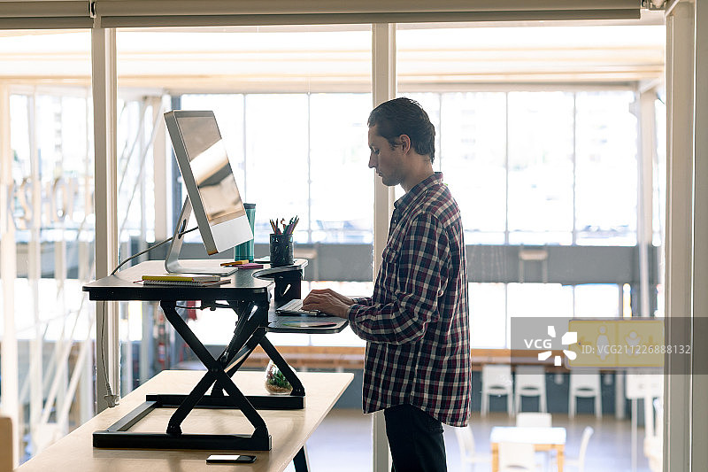在办公桌上用电脑工作的男性平面设计师图片素材